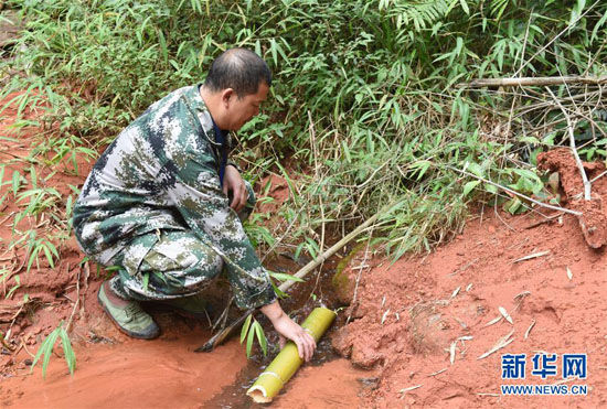 10月24日，貴州省赤水市葫市國有林場的一名生態護林員用廢竹筒接取山泉水。  新華社記者 黃曉勇 攝