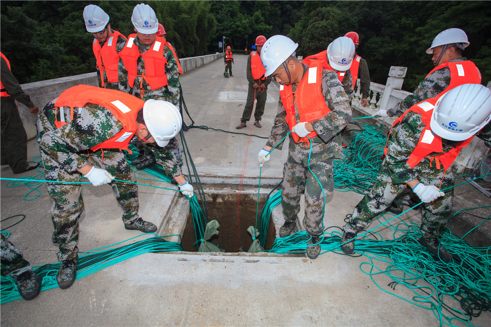 5月25日，長江水利委員會在陸水水庫組織開展2021年水庫防汛搶險應急演練。圖為1號B副壩爆破分洪演練現場，爆破器材已就位，搶險人員正輕放沙料。彭江 高志超攝