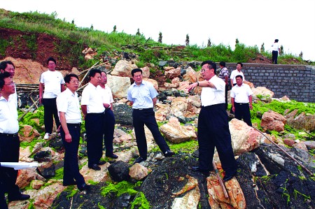 14日上午，威海市副市长唐会礼（前右二）一行来到乳山市海阳所镇、银滩开发区海边，对浒苔的现场打捞和处置进行考察。 于秉敏  摄