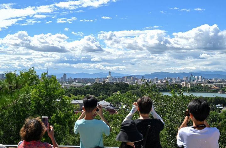 游客从北京景山上拍摄远处的北海公园（2024年8月12日）。新华社记者 李鑫 摄